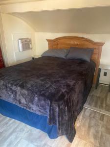 a bedroom with a large bed with a wooden headboard at Park Model Furnished #5 in Tucson