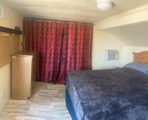 een slaapkamer met een bed en rode gordijnen bij Park Model Furnished #5 in Tucson