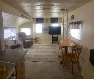 a living room with a television and a table and chairs at Park Model Furnished #5 in Tucson
