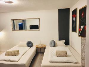 Zimmer mit 2 Betten und einem Spiegel in der Unterkunft Apartment- Metzingen in Metzingen