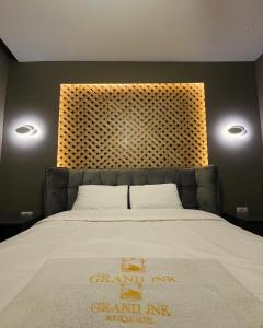 um quarto com uma cama com uma grande cabeceira de cama em GRAND JNK Boutique Hotel em Kukës