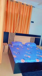 Una cama con un edredón azul con flores. en Timba Deluxe en Cotonú