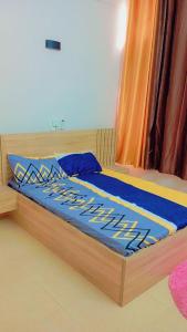 Una cama con un edredón azul encima. en Timba Deluxe en Cotonú