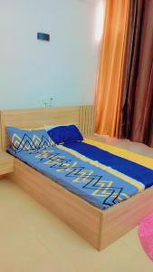 a bed with a blue comforter on top of it at Timba Deluxe in Cotonou