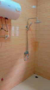 y baño con ducha y pared de madera. en Timba Deluxe en Cotonú