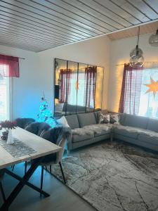 uma sala de estar com um sofá e uma árvore de Natal em Kulta Villa em Vuokatti