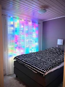 um quarto com uma cama e uma janela com luzes em Kulta Villa em Vuokatti