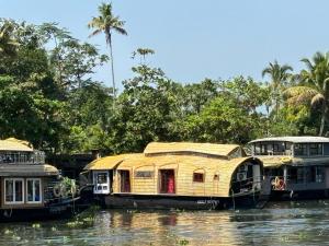 two boats on a river with trees in the background at PUNNAMADAKKARAN CRUISE in Alleppey