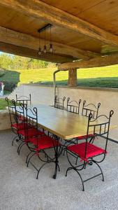 a wooden table with four chairs around it at Maison de campagne - Chez Félicien in Recologne-lès-Rioz