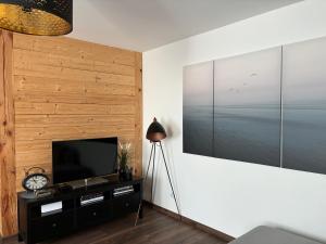 sala de estar con TV de pantalla plana en la pared en Cozy seaside park apartment en Liepāja