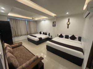 a hotel room with two beds and a couch at Hotel Life Inn in Jaipur