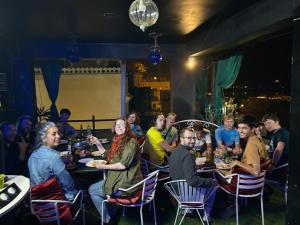 a group of people sitting at tables in a restaurant at Tamasha Udaipur in Udaipur