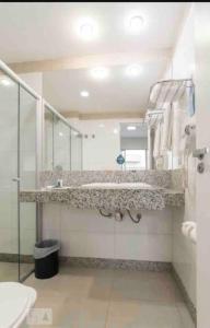 a bathroom with a sink and a mirror at Apartamento Completo ao lado da lagoa da Pampulha in Belo Horizonte