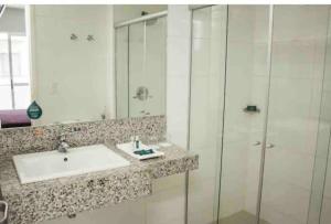 a bathroom with a sink and a shower at Apartamento Completo ao lado da lagoa da Pampulha in Belo Horizonte +1 photo