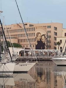 dos barcos están atracados en un puerto deportivo con un edificio en bb45 superior holiday's house CIR 19082053C204471, en Palermo