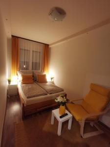 niewielka sypialnia z łóżkiem i krzesłem w obiekcie Római 1 w mieście Dunaújváros