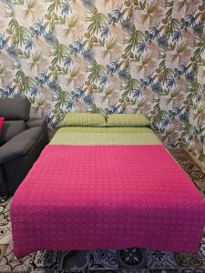 uma cama rosa num quarto com uma parede em Eterna Primavera Fayna em Granadilla de Abona