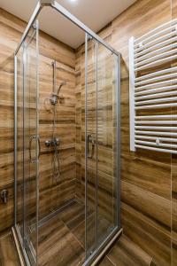 um chuveiro na casa de banho com paredes de madeira em Apartman Sneža Zlatibor em Zlatibor