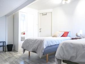 a white bedroom with a bed and a mirror at Favorita in Motala