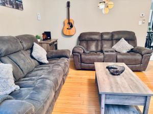 a living room with two couches and a coffee table at Bright, Stylish & Cozy 2Bed Unit w/Backyard & Grill Close to NYC! in Haledon