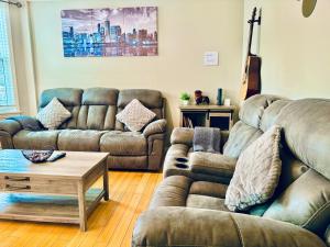 Sala de estar con 2 sofás y mesa de centro en Bright, Stylish & Cozy 2Bed Unit w/Backyard & Grill Close to NYC! en Haledon