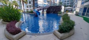 芭達雅中心的住宿－Grand Avenue, Luxury Suite, 72sqm pool view with lounge area，大楼内一个带滑梯的大型游泳池