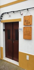 a building with a brown door and a sign on it at Morgado Guest House in Ervedal