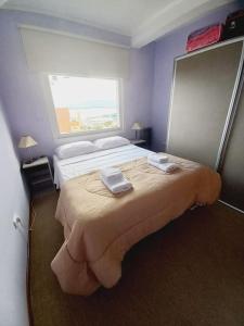ein Schlafzimmer mit einem großen Bett mit zwei Handtüchern darauf in der Unterkunft Departamento en zona residencial in Ushuaia