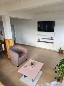 ein Wohnzimmer mit einem Stuhl und einem Tisch in der Unterkunft Departamento en zona residencial in Ushuaia