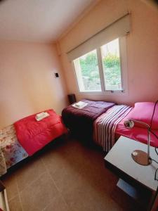 ein Schlafzimmer mit zwei Betten und einem Fenster in der Unterkunft Departamento en zona residencial in Ushuaia + 2 Fotos