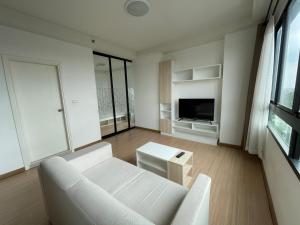 a living room with a white couch and a tv at 1BR Apartment in Bangkok