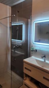 y baño con ducha, lavabo y espejo. en Privat apartment hotel Belvedere**** en Bansko