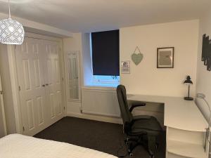 Margate Apartment في Kent: غرفة نوم مع مكتب وكرسي