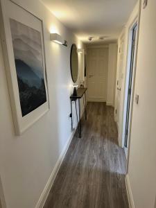 a hallway with a table and a mirror on a wall at Margate Apartment in Kent