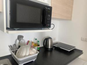a kitchen counter with a microwave on a counter top at 1BR Apartment in Bangkok