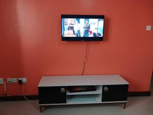 a living room with a tv on a red wall at J's Nest in Kericho