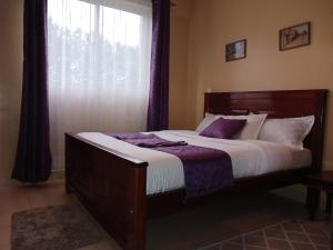 um quarto com uma cama grande e uma janela em J's Nest em Kericho