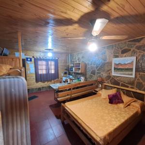 a room with two beds and a stone wall at Las Moras in Reyes