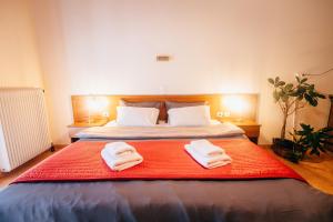ein Schlafzimmer mit einem Bett mit zwei Handtüchern darauf in der Unterkunft Mountain Hotels "Aroanides" in Planitéron