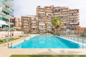 an image of a swimming pool in front of a building at Relax, vacaciones y lujo a 15 metros del mar in Arenales del Sol