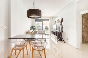 a dining room with a glass table and chairs at Relax, vacaciones y lujo a 15 metros del mar in Arenales del Sol