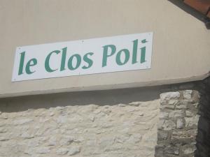 Un panneau qui dit leos poli sur un bâtiment dans l'établissement Chambres d'hôtes Le Clos Poli, à Montigny-les-Monts