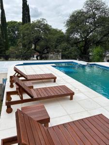 - une piscine avec deux bancs et une table de pique-nique dans l'établissement La Posta del Jesuita, à Villa Los Aromos