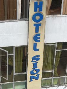 a sign for a hotel on the side of a building at Hotel SION in Pitalito