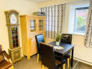 a dining room with a table and chairs and a clock at Scandinavian Apartment Hotel - Tobaksgården Budget - 2 room apartment in Horsens