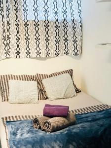 Una cama con dos almohadas y una manta. en Scandinavian Apartment Hotel - Tobaksgården Budget - 2 room apartment, en Horsens