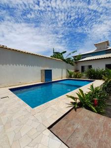 a swimming pool in front of a house at Renascer Suites in Búzios
