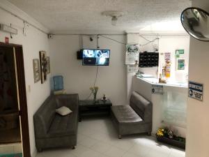 a waiting room with two chairs and a tv on the wall at Hotel SION in Pitalito