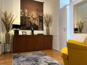 un salon avec un canapé jaune et une photo d'une ville dans l'établissement Hotel Antoni, à Bochum