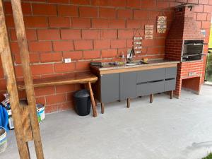- une cuisine avec un évier et un mur en briques dans l'établissement Casa condomínio, à Mairinque